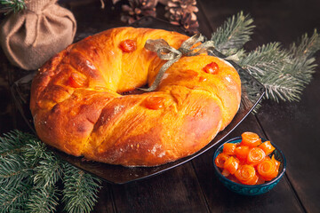 Home baked Christmas bread in a shape of Advent wreath of yeast dough with orange candied fruits on...