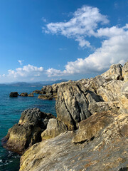 Fototapeta na wymiar Rocky coastline, blue water, seascape background