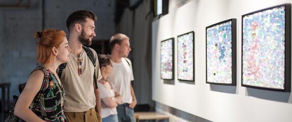 Group of friends in modern art exhibition gallery hall contemplating artwork. Abstract painting - obrazy, fototapety, plakaty