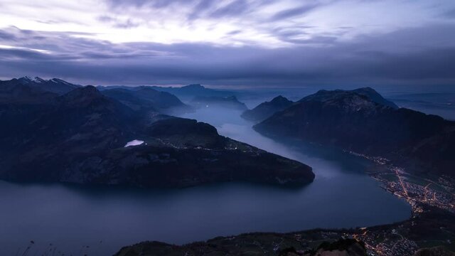 Day to night time lapse of Lake Lucerne as seen from Fronalpstock, Switzerland with a panoramic view of the fjords and mountain peaks