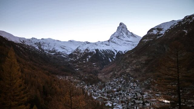 Day to night timelapse of the Matterhorn as seen from Zermatt, Switzerland as the stars light up the sky along with the city lights