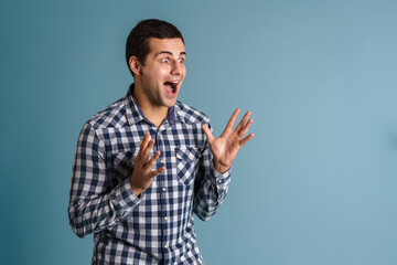 Excited young casual man gesturing isolated