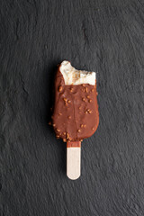 Ice cream bar with vanilla icing and chocolate on black background