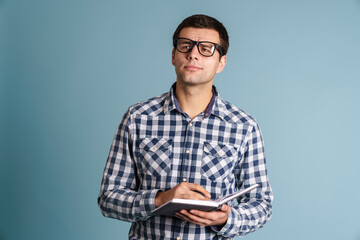 Handsome smart young man writing notes