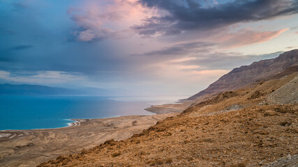 Fototapeta na wymiar Beautiful Israeli landscape: clouds over the Dead Sea, the lowest place on Earth, its north-western shore covered in sinkholes