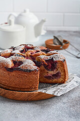 Plum cake rustic homemade on light stone background. Selective focus.