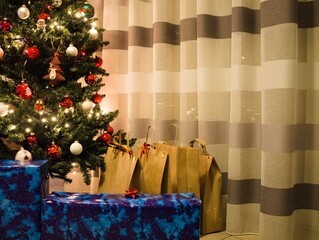 Christmas presents under the Christmas tree near a striped curtain (Marche, Italy, Europe)