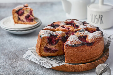 Plum cake rustic homemade on light stone background. Selective focus.