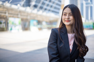 Happy smart businesswoman smiling in the city.