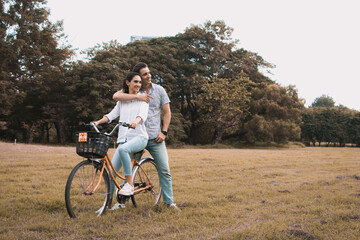 Happy young couple cycling in summer in the garden