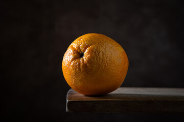 Orange on a wooden surface. Citrus fruit. One whole orange