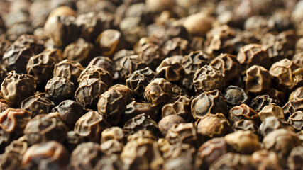 Whole black pepper close up, texture, background. Macro background of black hot pepper. Round black pepper background texture. Black peppercorns macro, texture. Background, texture of spices.