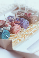 Close up of gift set of four colored decorative natural beewax candles with dried flowers and a honey aroma for interior and tradition. Selective focus. A delicate color palette