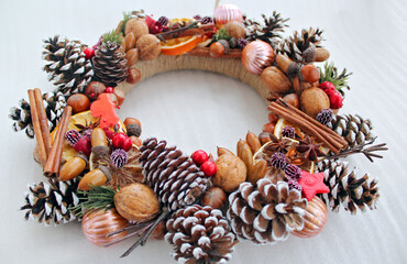 Handmade Christmas wreath of pine cones, oranges, nuts, and beads