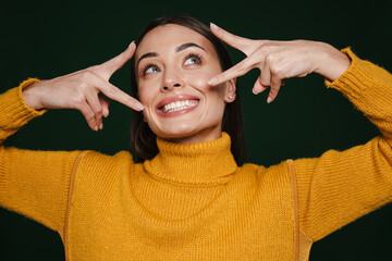 Joyful beautiful girl smiling and showing peace gesture