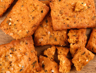 Cookies with crumbs with coarse salt and spices on a wooden board.