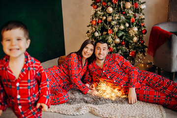 Happy family having at Christmas time. Father, mother and son at home. Xmas holiday concept