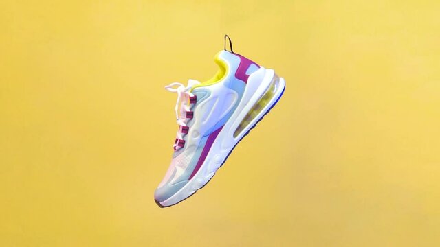 Spinning sports shoe concept, white shoes with a blend of colorful lines. Sport shoe rotation isolated on yellow background. Blue and red lighting from the side of the shoe. illustration of sport shoe