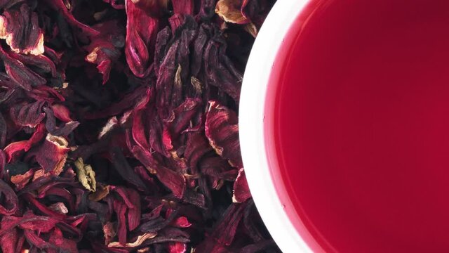 Rotation cup of hibiscus tea on the leaves. View from above.
