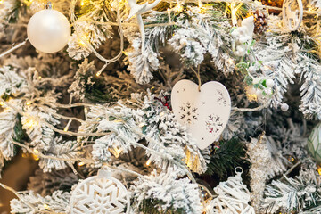 White Christmas toys, balls garlands on a spruce branch with copy space