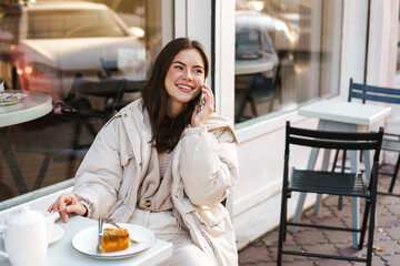 Beautiful smiling young woman using mobile phone