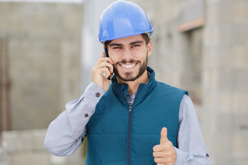 young constructor on the phone showing thumb up