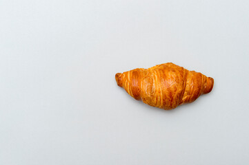 Fresh tasty croissant on grey background. French pastry