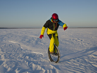 Unicyclist rides in the snowy desert