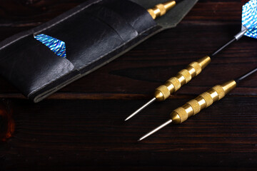 Darts for playing darts on a dark wooden background. Darts game.