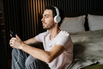 Calm man listening music with cellphone and headphones