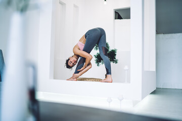 Young woman doing yoga in spacious room