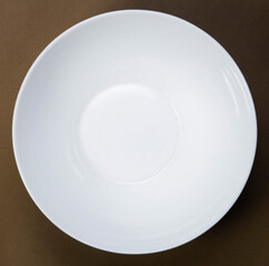 Mock up empty deep white plate on yellow background, top view