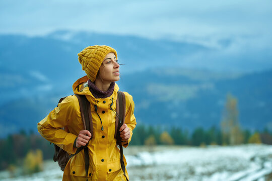Woman hiking in mountains alone, calm treveler girll peaceful looking away, enjoing winter nature outdoors