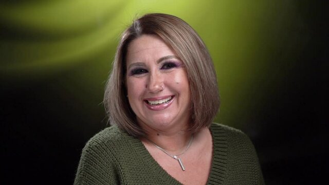 Beautiful  mature woman smiles and flirts at the camera tilts her head