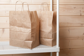 Two recycling paper bags stand on a white shelf