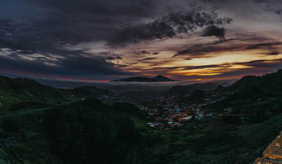 Atardecer en una isla con volcán, con vistas a un pueblo en un valle