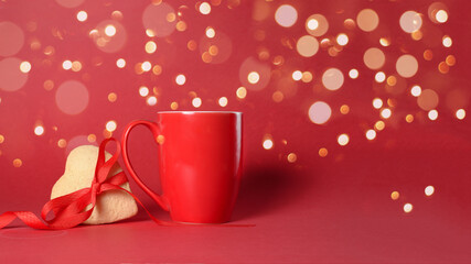 red Cup with gingerbread heart on red bokeh background light garlands, Valentine's day holiday. the mocap copyspace