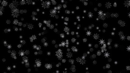 Falling snowflakes close up on isolated black background in space.