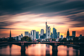 Fototapeta na wymiar What a mood in the sky, sunset with incredible clouds and colors with a view over the Main. The Frankfurt skyline can be seen in the background. Shipping romance on the river in Germany
