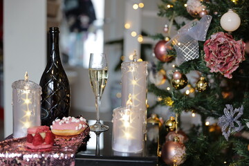 Three candles with stars, bottle of wine with glass of champagne, Christmas tree, xmas time decoration