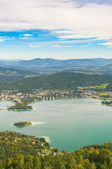 Fototapeta premium Panorama of Lake and mountains at Worthersee Carinthia Austria. View from Pyramidenkogel tower on lake and Klagenfurt the area.