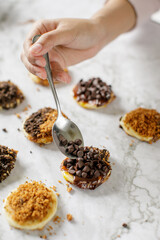 a lady putting crunches of chocolate chip on a pancake