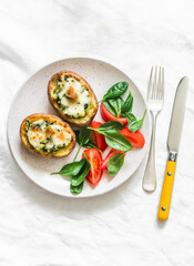 Roasted potatoes stuffed spinach and mozzarella on a light background, top view. Delicious tapas, snack, appetizers