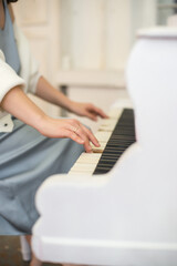 Fototapeta na wymiar Person playing on white piano