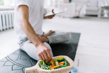 Unrecognizable man eating vegetable salad