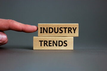 Industry trends symbol. Wooden blocks with words 'Industry trends' on beautiful grey background. Male hand. Business and industry trends concept, copy space.