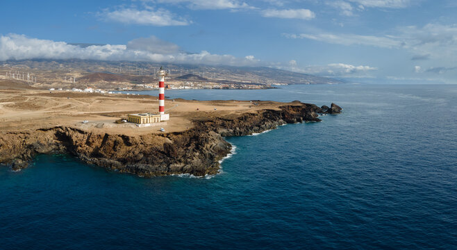 A view to the east at the red white lighthouse Poris on the south coast of the Spanish island of Tenerife in the Atlantic, photographed from the air. It is a sunny September day.