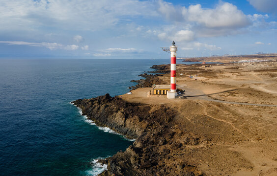 The red and white lighthouse Poris on the south coast of the Spanish island of Tenerife in the Atlantic, photographed from the air. It is a sunny September day. The view is to the west.