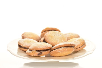 Shortbread biscotti with white ceramic dishes, close-up, on a white background.