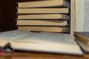 An open book on the background of a stack of books. Reading a book. close-up of an old book open on...